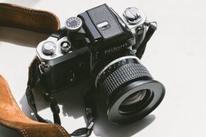 black Nikon DSLR camera on white surface